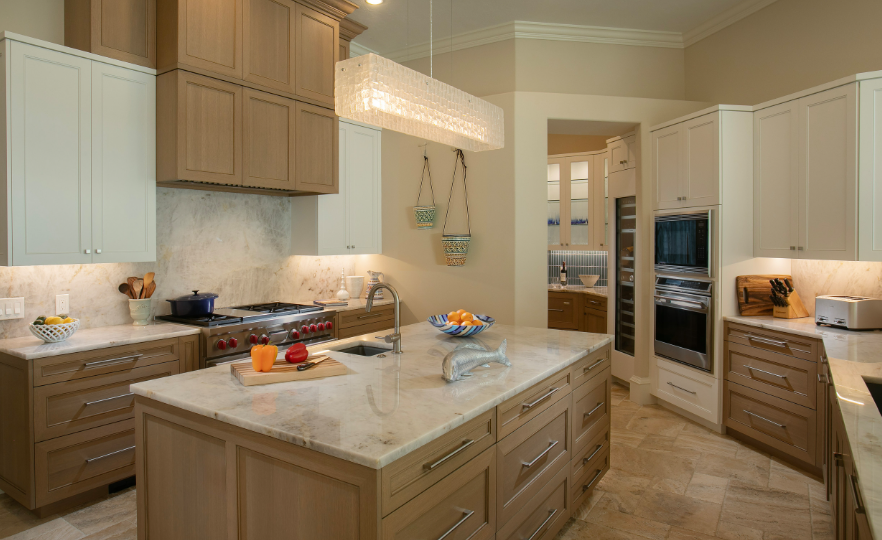 High-end kitchen cabinets Sarasota — two-tone transitional kitchen featuring natural wood lower cabinets and white upper cabinetry with marble countertops by EuroTech Cabinetry
