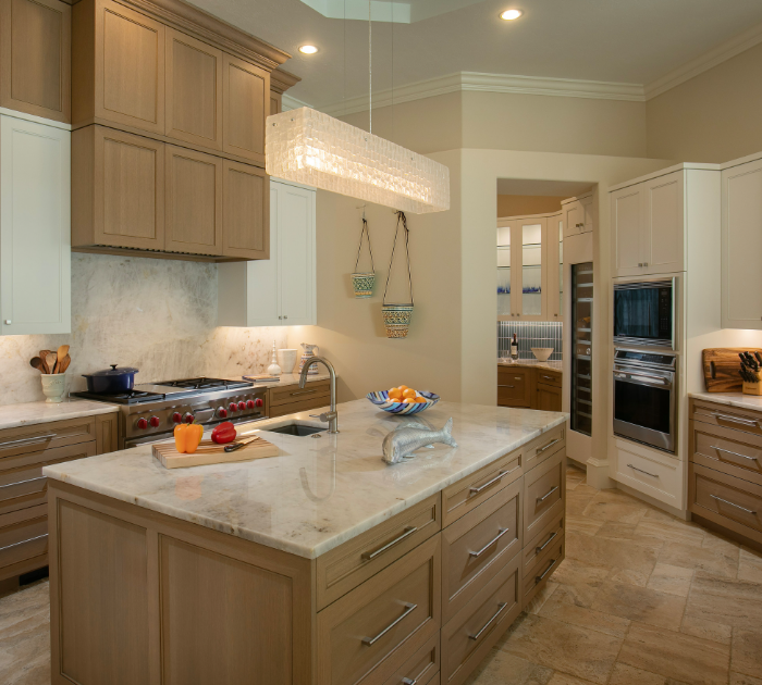 High-end kitchen cabinets Sarasota — two-tone transitional kitchen featuring natural wood lower cabinets and white upper cabinetry with marble countertops by EuroTech Cabinetry